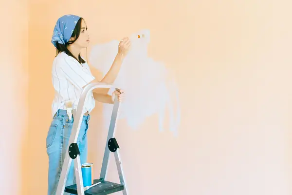 Interior painting in Provo: painter on a stepladder rolling a wall